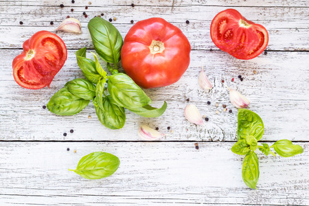 Spices black pepper, garlic, basil and tomatoes. Ingredients for cooking. On the white wooden background.の写真素材