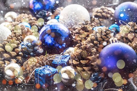 Christmas background with blue ornaments and snowy pinecone and bokeh. Christmas party decoration with shiny balls.の写真素材