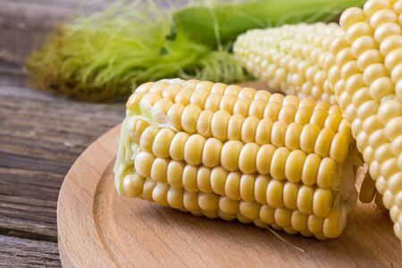 Fresh corn on cobs on rustic wooden table, closeup.の写真素材