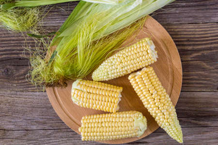 Fresh corn on cobs on rustic wooden table, closeup, top view, copy space.の写真素材