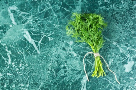 A bunch of fresh dill on marble background. Empty space for text.の写真素材