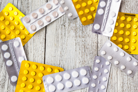 Pills border background. Vitamins, tablets, pills in blister pack on white wooden background. Top view. Copy space for textの写真素材