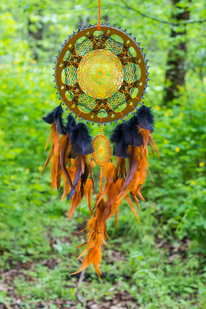 Black and orange dreamcatcher with star made of feathers leather beads and ropes, hangingの写真素材