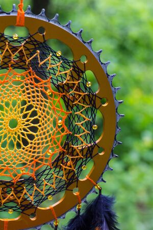 Black and orange dreamcatcher with star made of feathers leather beads and ropes, hangingの写真素材