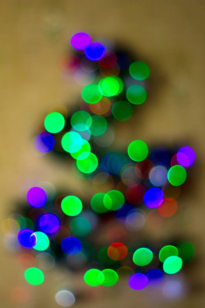 Christmas fir tree out of focus on a white background. Reflexes bokeh, repeating the shape of triangular shape.の写真素材