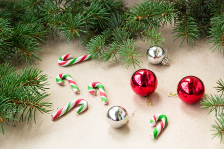 Festive christmas border with red and silver balls on fir branches and snowflakes on rustic beige background with copyspace and pen.の写真素材
