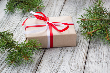 Christmas background with gift and fir tree on white wooden table. Top view with copy space. Gift wrappingの写真素材