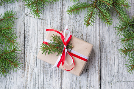 Christmas background with gift and fir tree on white wooden table. Top view with copy space. Gift wrappingの写真素材