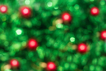 Defocused abstract green background with red. Blurred holiday bokeh.の写真素材