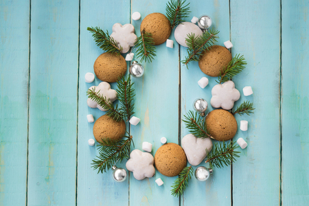 Christmas wooden background with tree branches, gingerbread and marshmallows.の写真素材