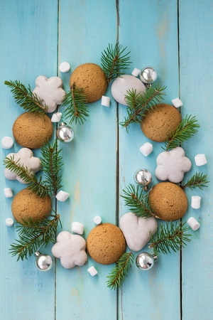 Christmas wooden background with tree branches, gingerbread and marshmallows.の写真素材