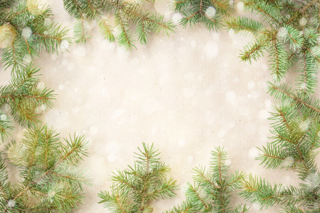 Festive christmas border with fir branches and snowflakes with snow on rustic beige background.の写真素材