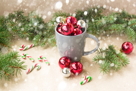 Silver and red christmas decorations balls in cup with fir tree and snow christmas background.の写真素材