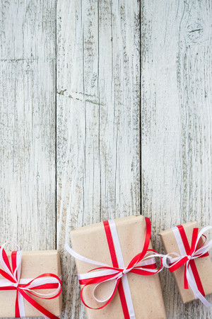 Presents for any holiday concept. Gift boxes frame, top view with copy space on wood table background.の写真素材