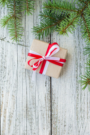 Border of Christmas gift boxes and fir tree branch on wooden table. Top view with copy spaceの写真素材