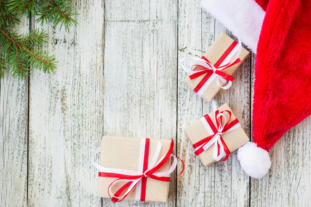 Christmas holiday wooden background with fir branches, Santa hat and gift boxes. top view, copy spaceの写真素材