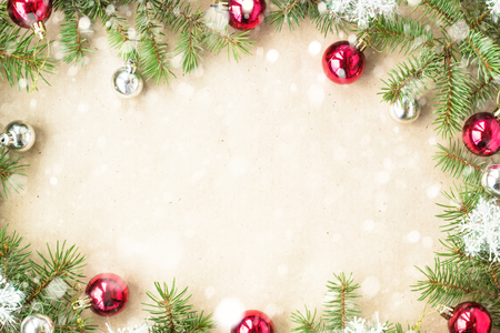 Festive christmas border with red balls on fir branches and snowflakes with snow on rustic beige background.の写真素材
