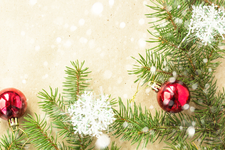 Festive christmas border with red balls on fir branches and snowflakes with snow on rustic beige background.の写真素材