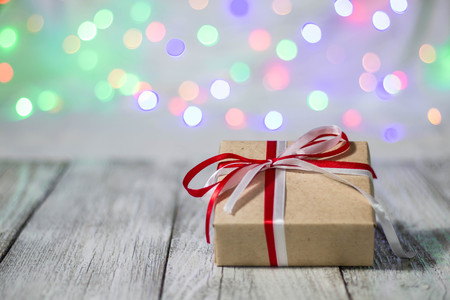 Christmas gift box against bokeh background. Holiday greeting card.の写真素材