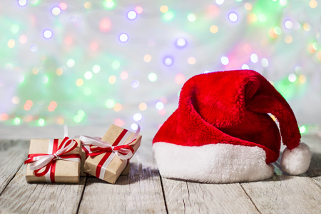 santa hat with christmas gift boxes against bokeh background.の写真素材