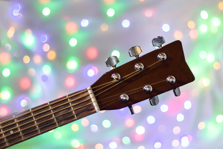 the neck of the acoustic guitar on christmas light bokeh background.の写真素材