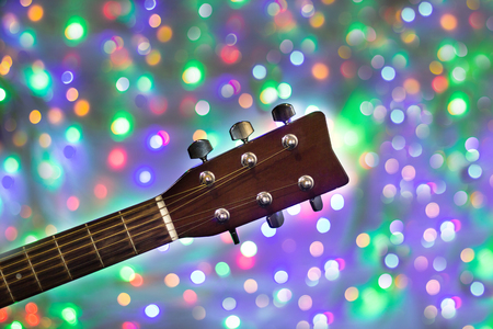 the neck of the acoustic guitar on christmas light bokeh background.の写真素材