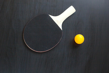 table tennis or ping pong racket and ball on a black background.の写真素材