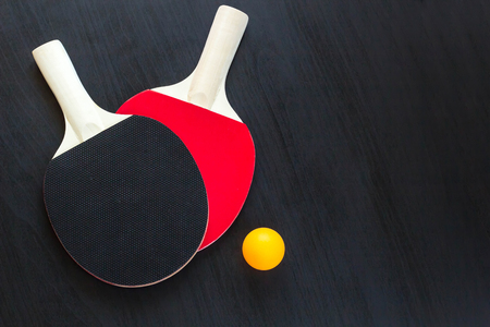 Two table tennis or ping pong rackets and ball on a black background.の写真素材