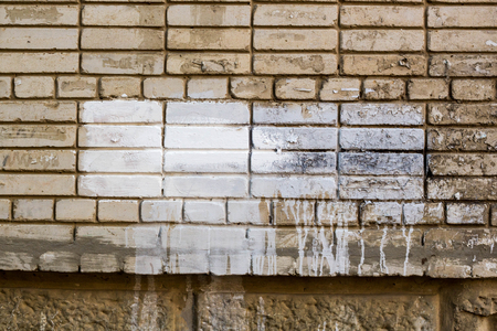 brick wall with painted splotch for your text and paper scraps as background or texture.の写真素材