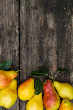 Frame of pears on dark wooden background. Harvest concept. Top view flat lay overhead. Copy space backgroundの写真素材