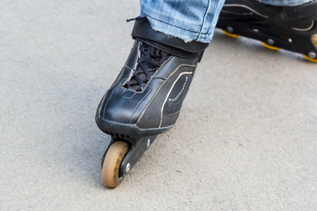 Young man in blue jeans riding roller skates in the city. Close up legs.の写真素材
