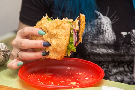 Close Up Of Man Hands Holding Delicious Burger and eating it. Fast food conceptの写真素材