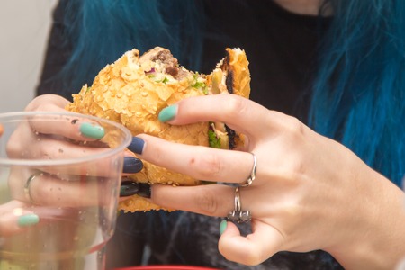 Close Up Of Man Hands Holding Delicious Burger and eating it. Fast food conceptの写真素材