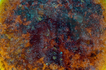 Stains of fat on the surface of water abstraction. Creative rough textured background.