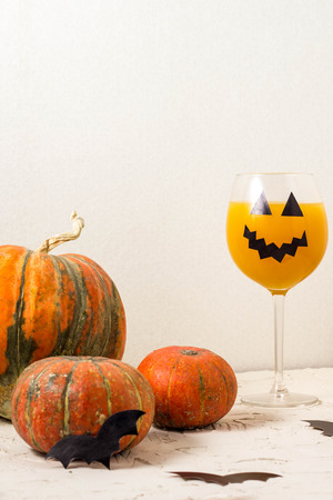Autumn orange holiday pumpkin cocktail with halloween decor on the table.の写真素材