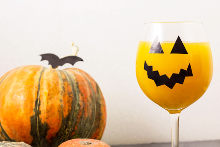 Autumn orange holiday pumpkin cocktail with halloween decor on the table.の写真素材