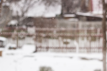 blurred background snow winter village small houses and trees.の写真素材