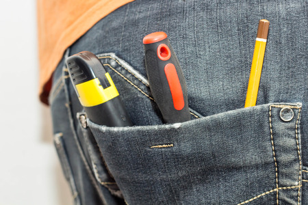 Engineering work tool in the back pocket of the jeans. pencil screwdriver hammer and a utility knifeの写真素材