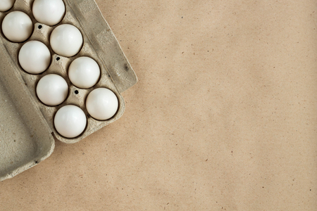 Cardboard egg rack with eggs on rustic background with copy space for text