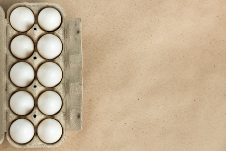 Cardboard egg rack with eggs on rustic background with copy space for text