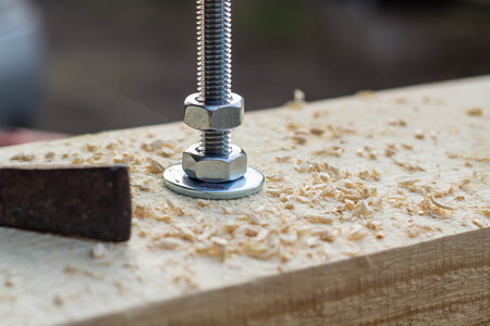 Bolt and nut twisted into a wooden board on the constructionの写真素材