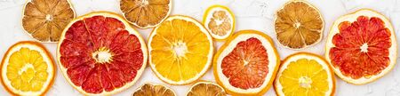 Border of Dried slices of various citrus fruits on white background. Many Orange lemon grapefruit...