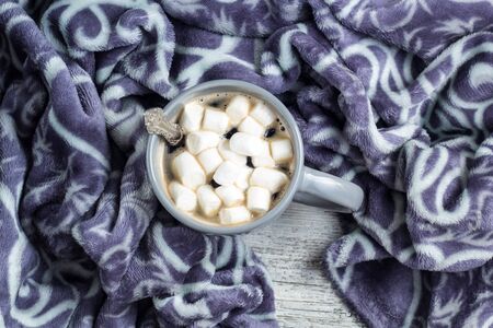 cup of coffee or cocoa with marshmallows and warm plaid on white wooden table. Christmas Winter concept.の写真素材
