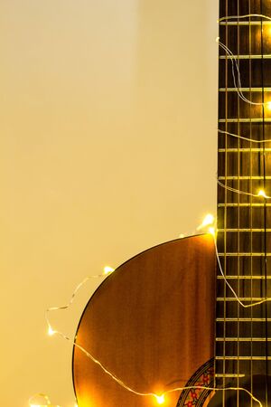 acoustic guitar wrapped in a luminous garland. Christmas gift with space for textの写真素材