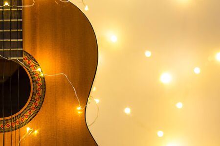 acoustic guitar wrapped in a luminous garland. Christmas gift with space for text