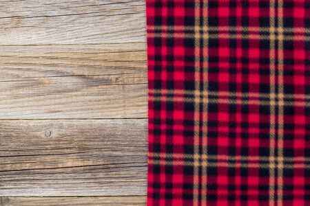 background of red checkered plaid and wooden boards. Top view with copyspaceの写真素材