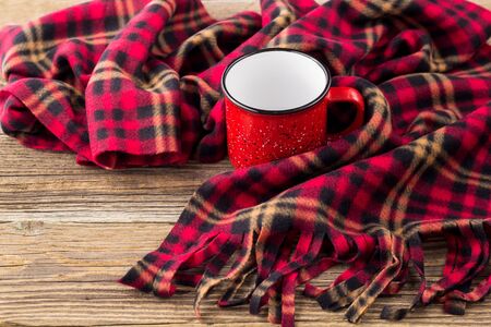 empty red cup and cozy plaid on natural wooden backgroundの写真素材