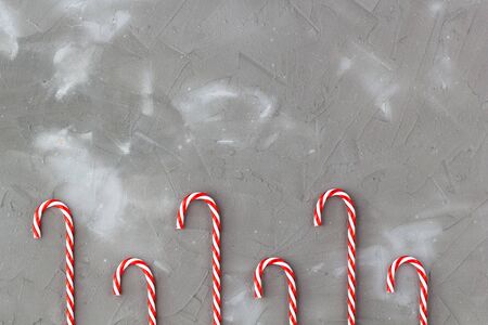 Border of red and white candy canes on grey background. Christmas holiday concertの写真素材