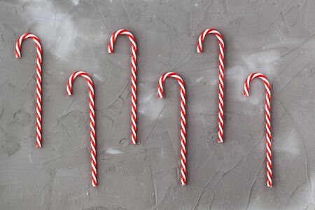 Border of red and white candy canes on grey background. Christmas holiday concertの写真素材
