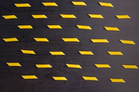 Pattern of A pile of penne pasta on dark black background